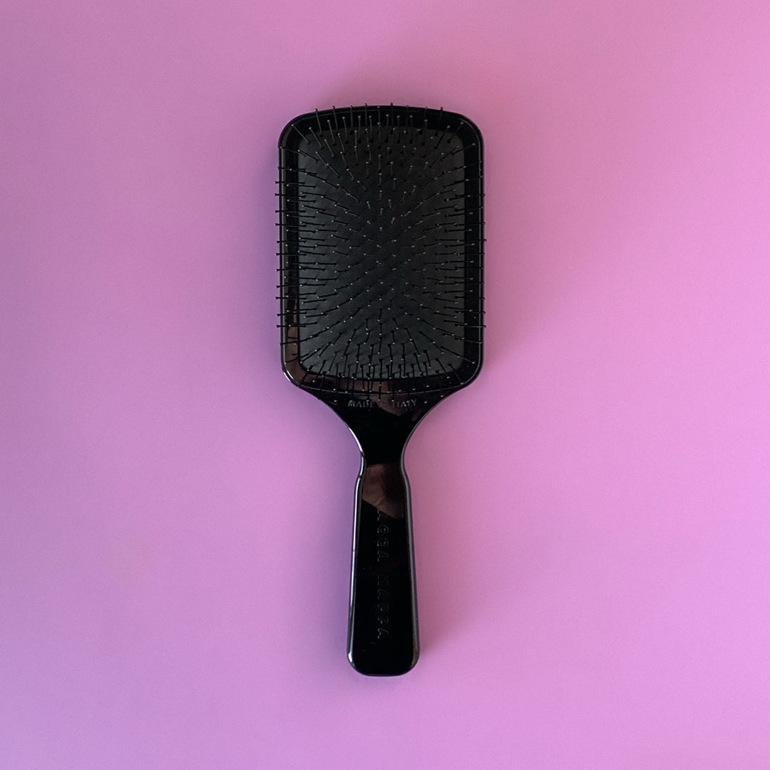 foto di una spazzola per la doccia con sfondo viola