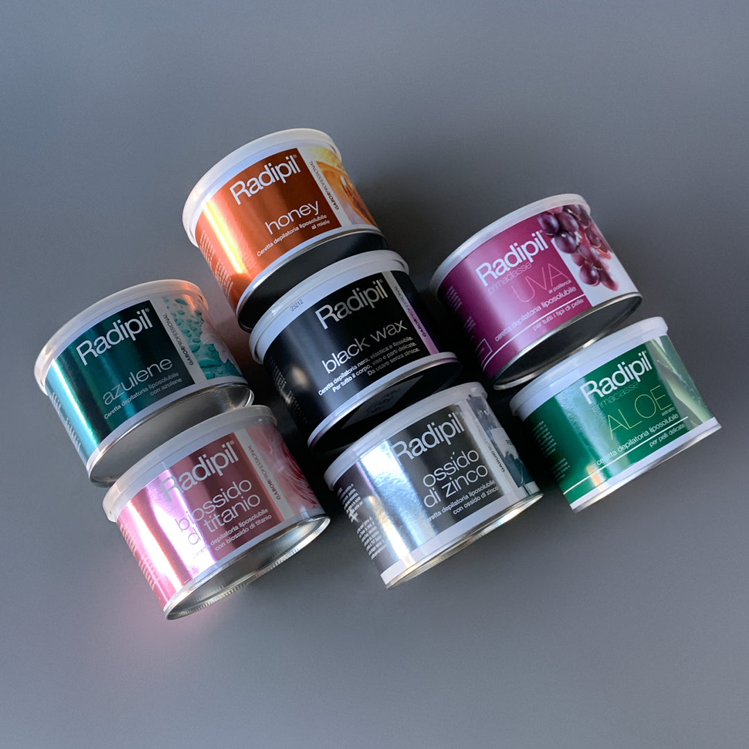 Foto su sfondo nuetro grigio con 7 cere diverse per fare la ceretta