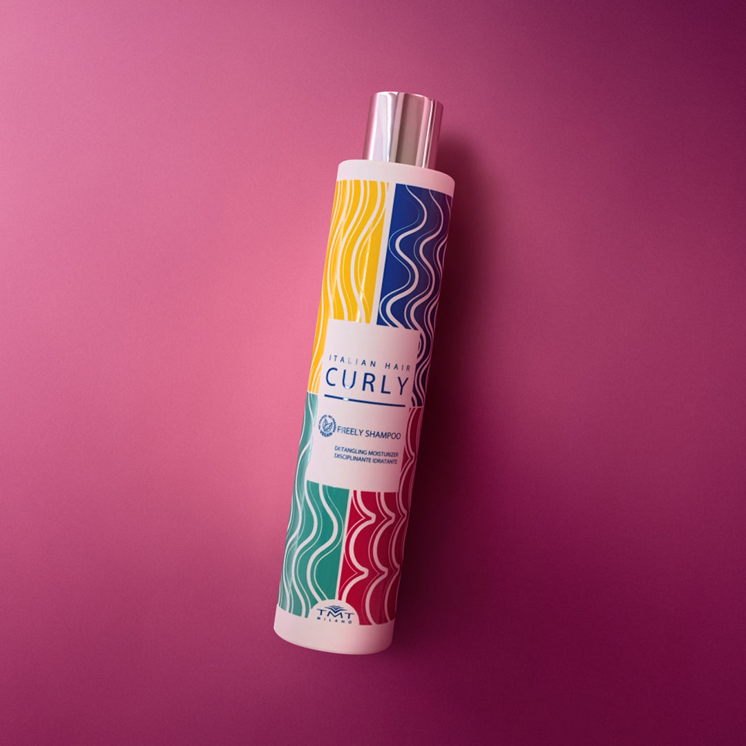 Flacone Curly Freely Shampoo di Tmt molto colorato che poggia su sfondo in tinta unita fucsia