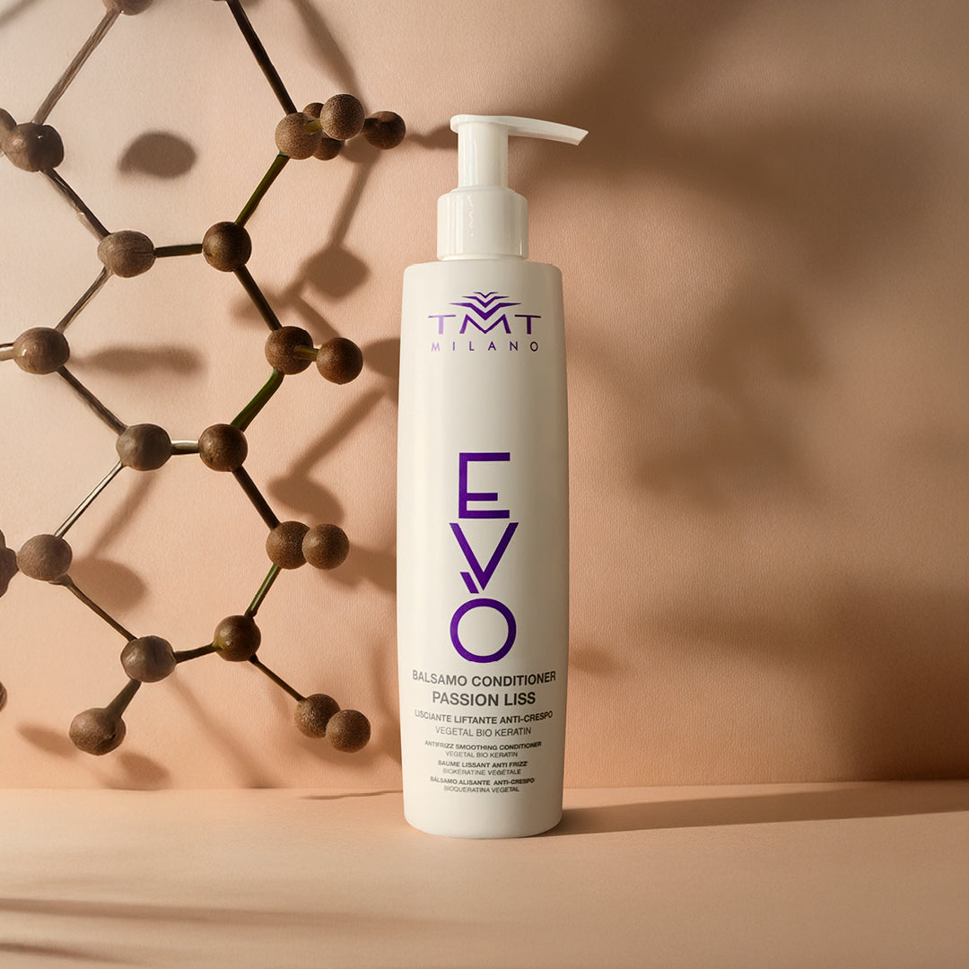 Flacone Evo Condizionante Lisciante su sfondo neutro grigio aranciato con una struttura di palline in legno