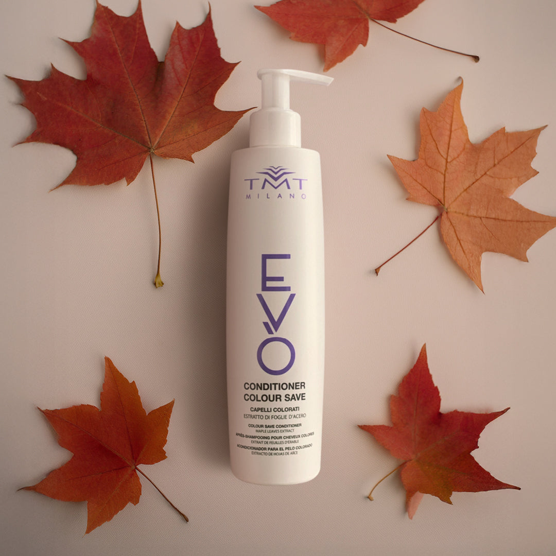 Flacone Evo shampoo antigiallo su sfondo neutro rosa con delle foglie di abete rosse