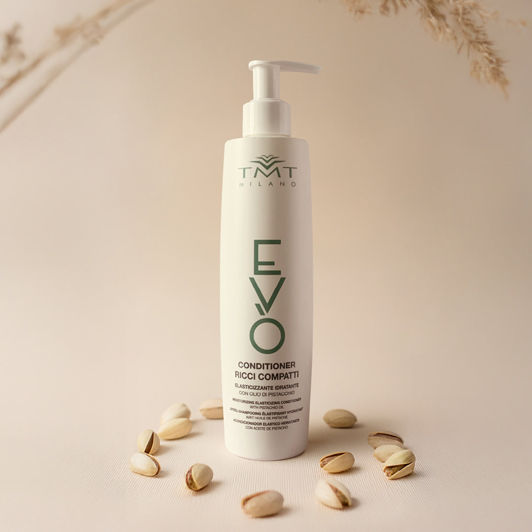 Flacone Evo Condizionante Ricci Compatti su sfondo neutro rosetta con attorno una arachidi