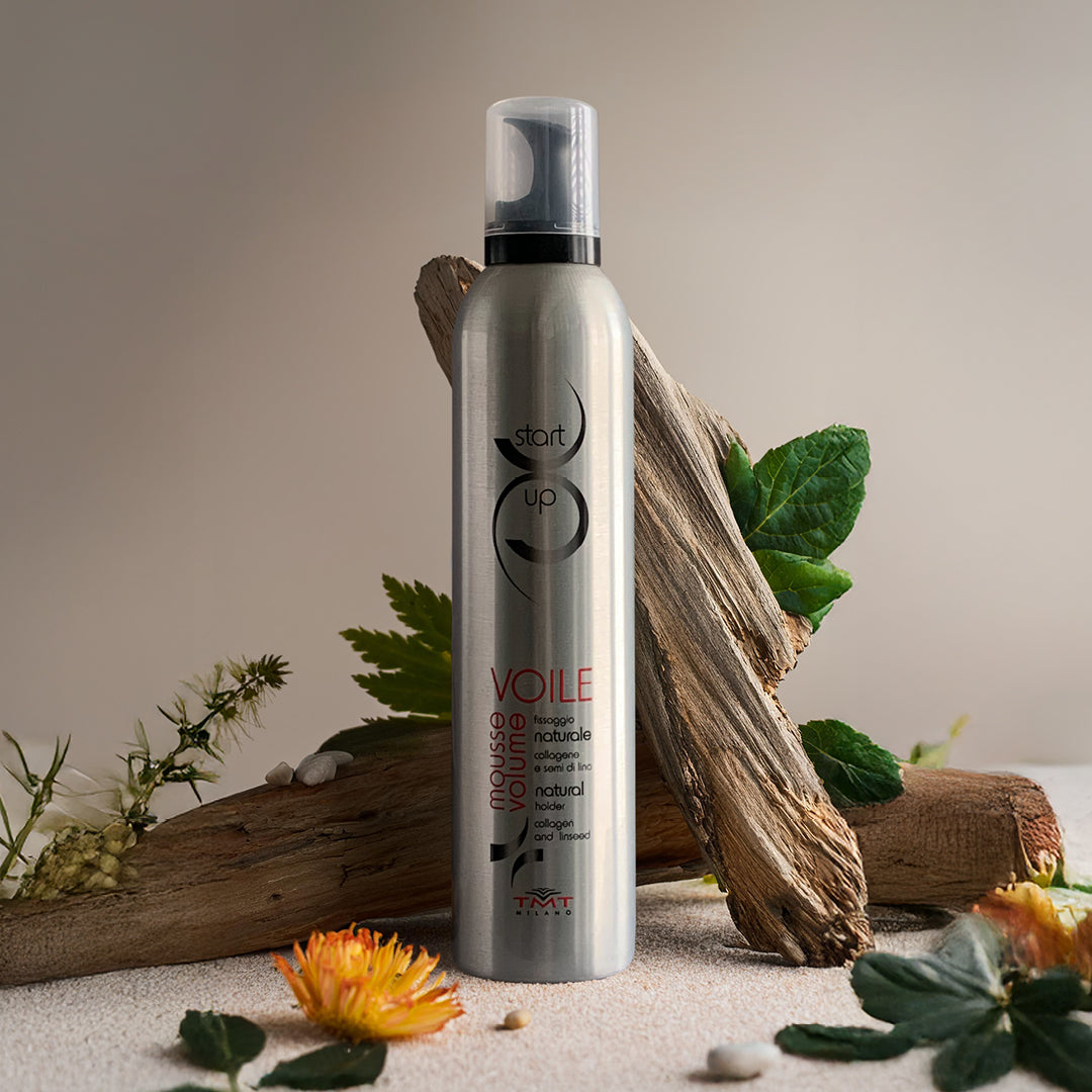 immagine della mousse volume su sfondo bianco con tronchi foglie e fiori