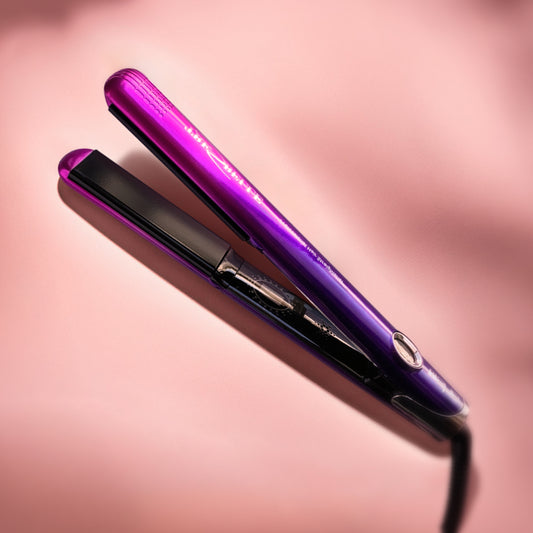 Piastra per capelli viola dalle sfumature rosa, che poggia su uno sfondo rosa