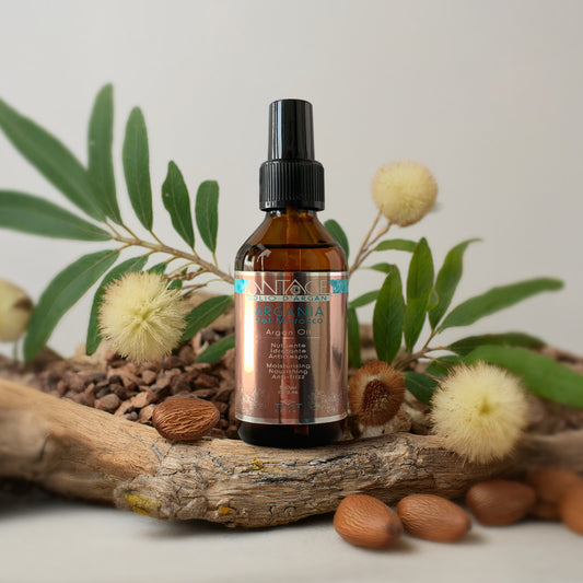 Prodotto Tmt Olio Nutriente che poggia su un tronco con attorno della corteccia, delle mandorle e dei soffioni.