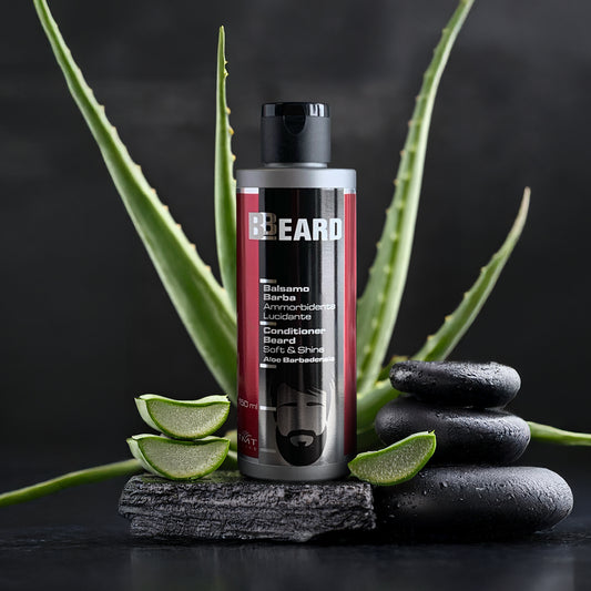 flacone di beard balsamo barba che poggia su dei sassi grigi e dietro aloe vera. Sfondo grigio