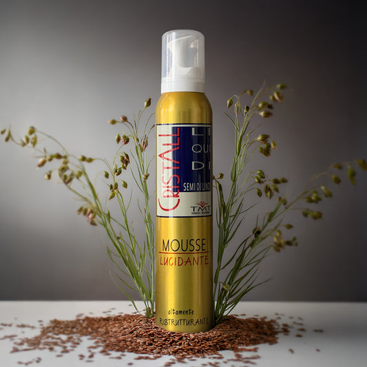 Prodotto TMT Mousse Lucidante isu sfondo nuetro grigio e il flacone poggia sui semi di lino