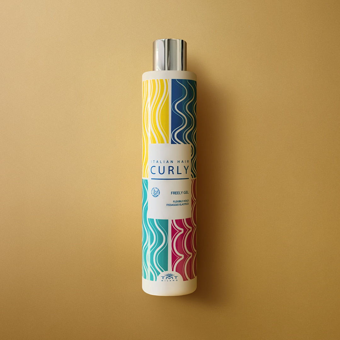 Flacone Curly Freely Gel di Tmt molto colorato che poggia su sfondo in tinta unita fucsia