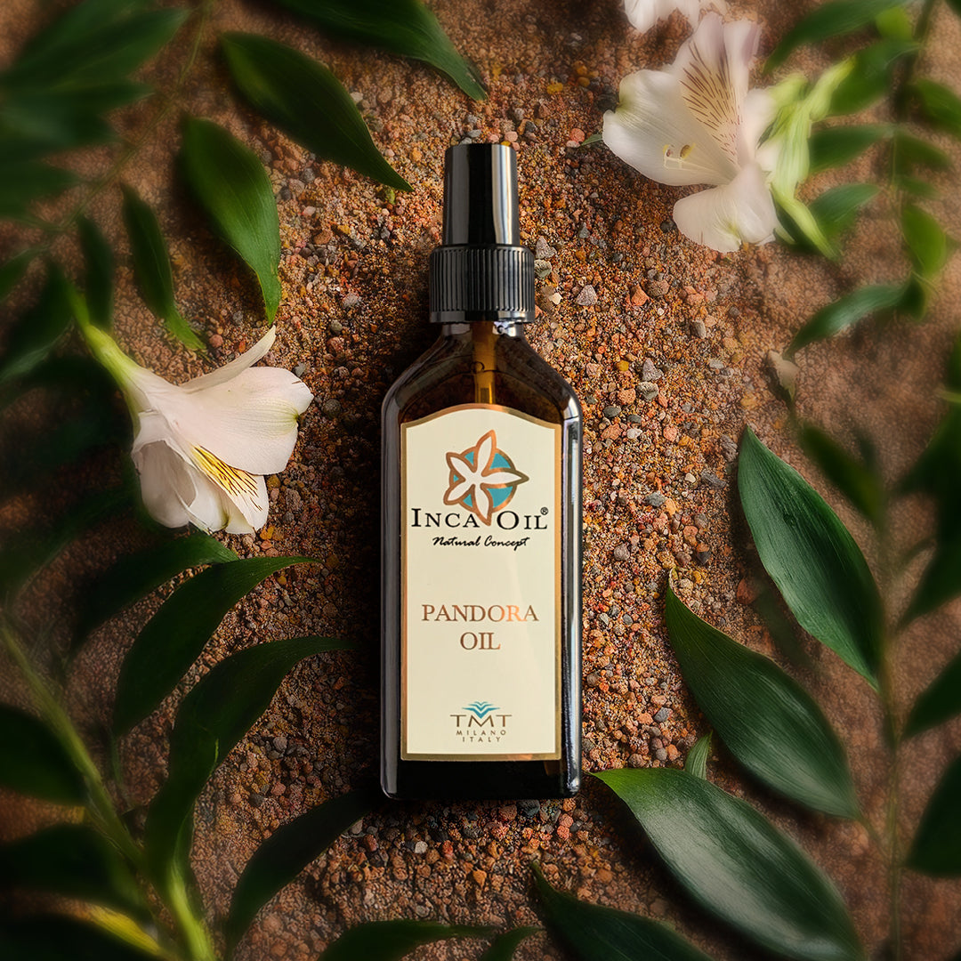 Prodotto Tmt Inca Oil che è l'olio di Pantora. Lo sfondo sono dei piccoli sassi colorati e tutto attorno delle foglie verdi con dei fiori bianchi